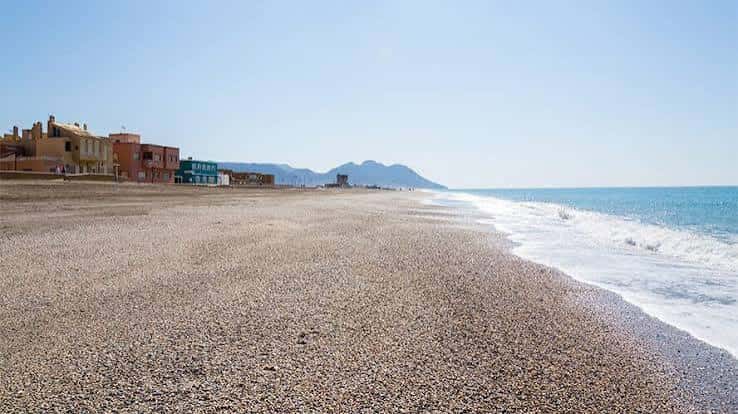 Amplia playa de El Palmeral con mar y montañas al horizonte