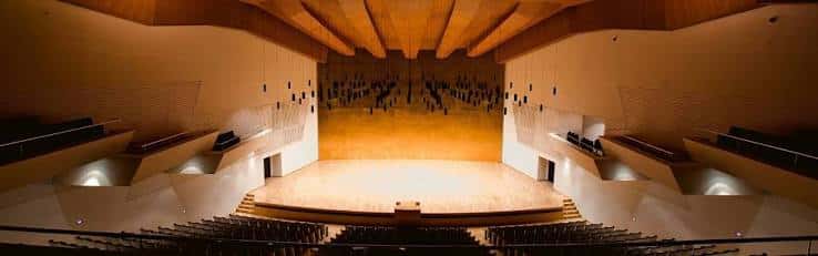 Interior panorámico de la Sala Sinfónica mostrando el escenario y las butacas bajo la estructura de madera del techo