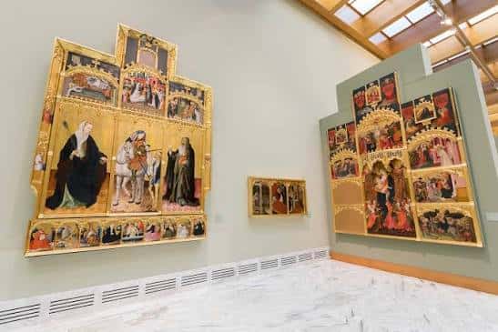 Sala de arte religioso con retablos dorados y pinturas de estilo gótico en exhibición