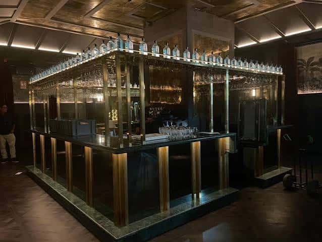 Bar central del restaurante Alegal con estantería de botellas y diseño moderno