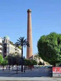 Vista de la Plaza de Valdeolleros con la chimenea industrial como punto focal