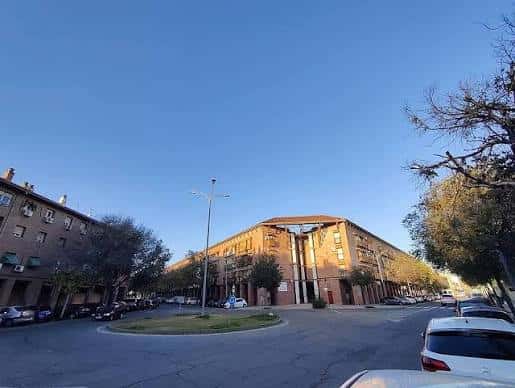 Plaza de Valdeolleros con edificios residenciales y árboles en primer plano