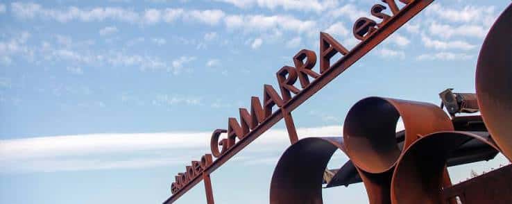 Señalización metálica con el nombre 'GAMARRA' en el exterior del complejo deportivo