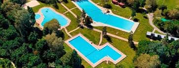 Vista aérea de las piscinas del complejo rodeadas de vegetación y zonas de descanso