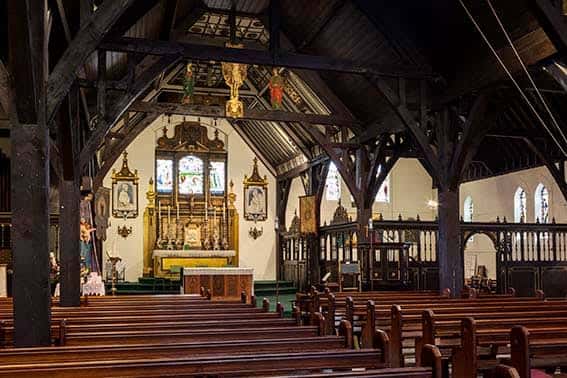 Interior de la iglesia con el altar principal y bancos de madera