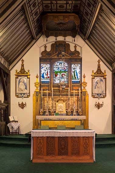 Primer plano del altar con vitrales y decoración religiosa