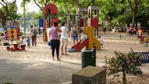 Área de juegos infantil en el parque con familias disfrutando del día