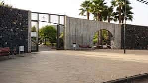 Entrada principal del Parque de la Vega con su distintiva arquitectura de piedra volcánica y arco