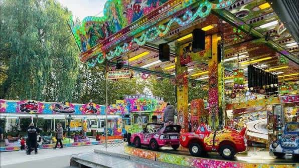 Atracciones de la Feria del Pilar en Vitoria, incluyendo un carrusel colorido y coches de choque