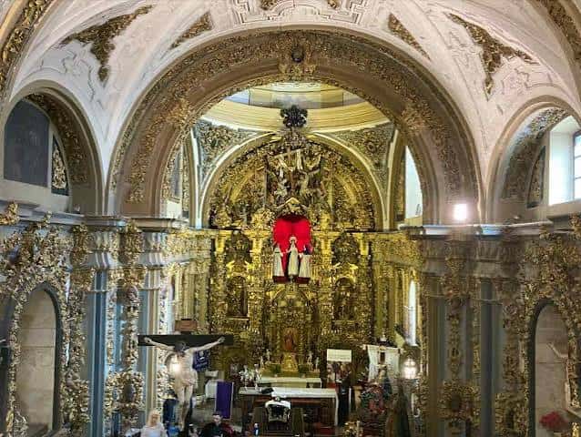 Interior de la iglesia mostrando el retablo mayor dorado y la nave central