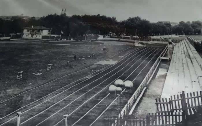 Vista panorámica de la pista de atletismo con gradas de madera y campo central