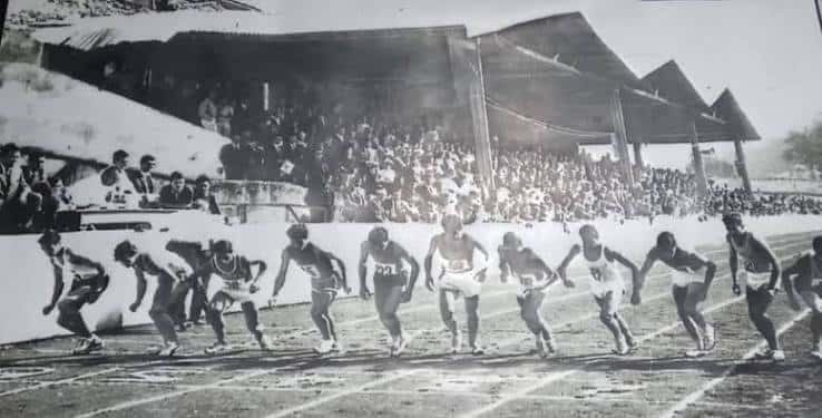 Carrera de atletismo en la pista con espectadores en las gradas