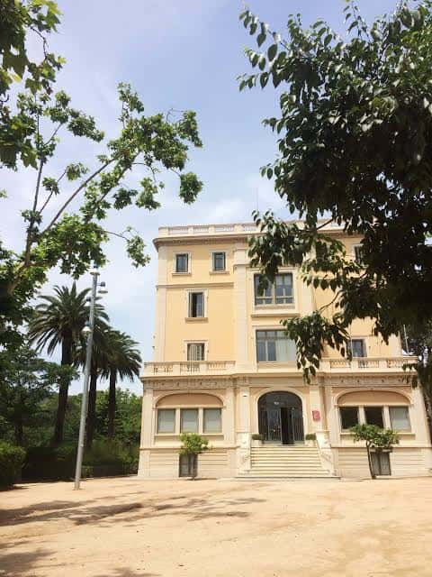 Fachada principal del Centre Cívic Sarrià con jardines y palmeras
