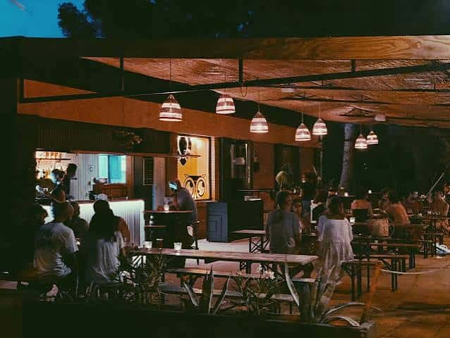 Terraza nocturna de EsBirra Ibiza con mesas, luces colgantes y ambiente relajado