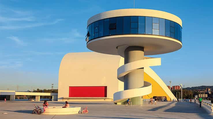Plaza exterior del Centro Niemeyer con personas disfrutando del espacio y la escalera helicoidal