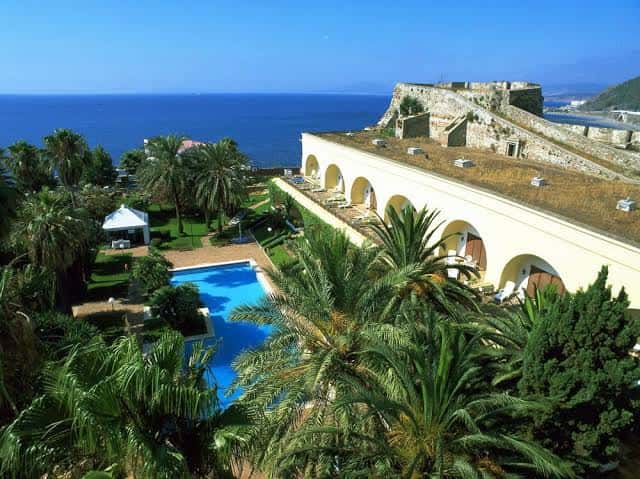 Vista aérea del complejo del Parador con jardines, piscina y fortaleza costera