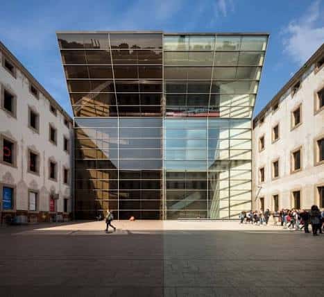 Vista frontal del patio principal del CCCB con la fachada de cristal y el edificio histórico