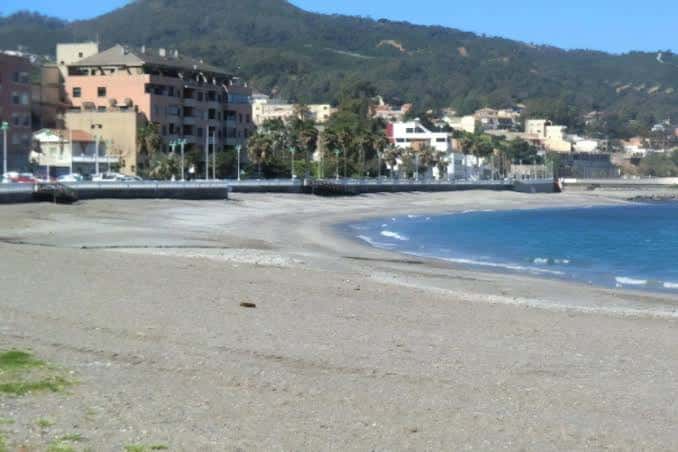 Vista panorámica de la Playa de Benítez con mar, arena y colinas verdes