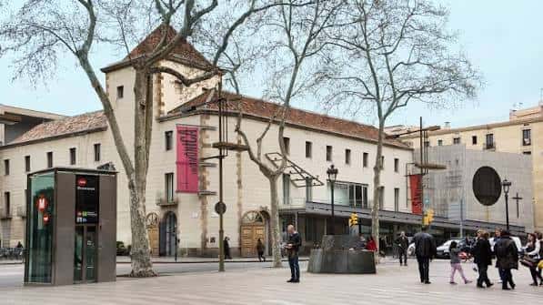 Plaza frontal del Centre d'Arts Santa Mònica con árboles y acceso principal