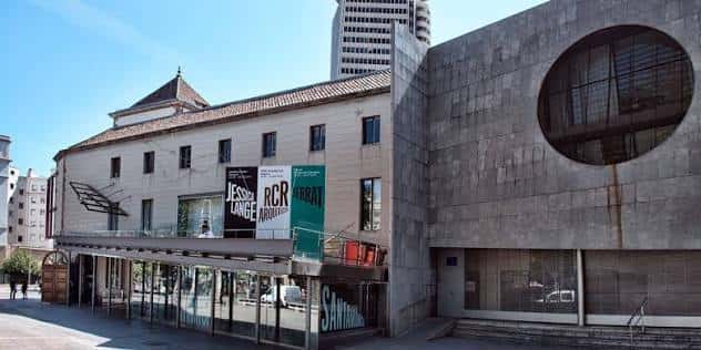 Vista panorámica de la fachada combinando el edificio histórico y la estructura moderna de hormigón