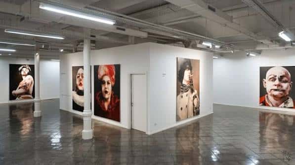 Interior de sala de exposiciones con obras de arte en blanco y negro y color