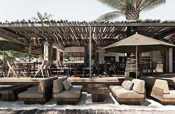 Zona de terraza del Beachouse Ibiza con mobiliario de madera y sombrillas