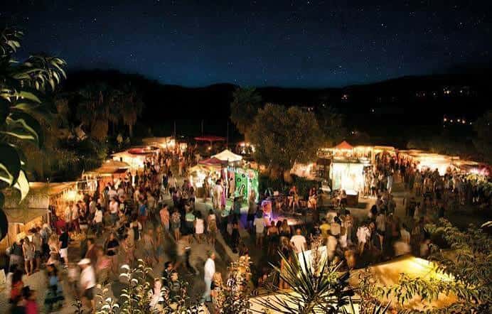Vista nocturna del mercadillo Las Dalias con ambiente festivo y luces decorativas