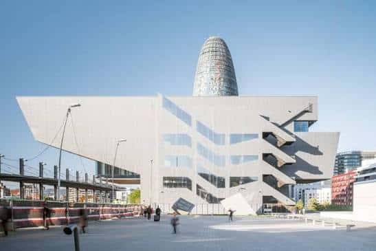 Fachada principal del edificio con escaleras exteriores y plaza abierta