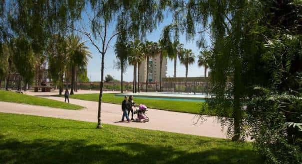 Paseo arbolado con familia paseando en el parque