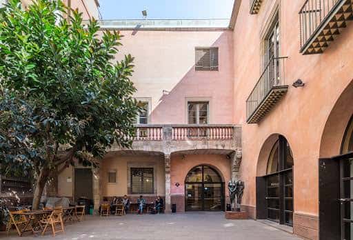 Patio interior del Centre Cívic Pati Llimona con mesas y sillas para eventos al aire libre