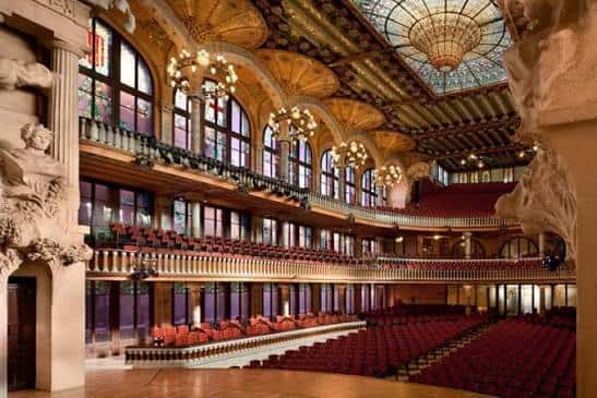 Interior del auditorio con butacas rojas y columnas ornamentadas