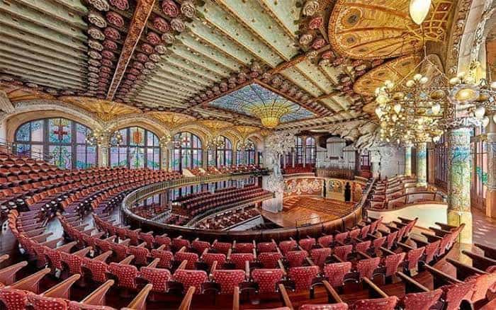 Interior del auditorio con techo decorado y butacas rojas