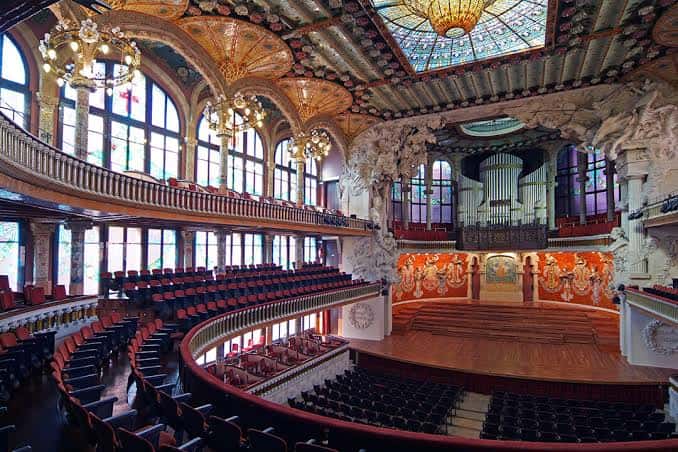 Interior del auditorio con vista al órgano y los murales decorativos en el fondo