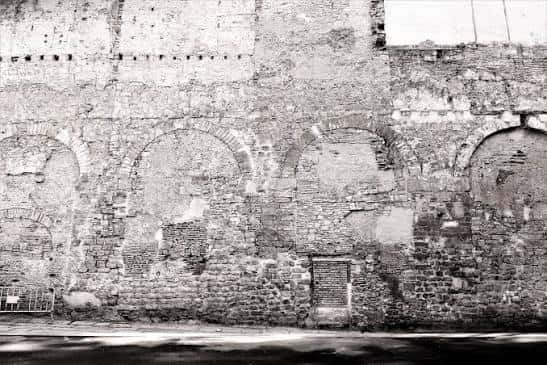 Fachada de la muralla romana con arcos y detalles arquitectónicos