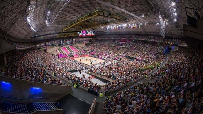 Vista panorámica del interior lleno durante un evento deportivo con iluminación en el escenario