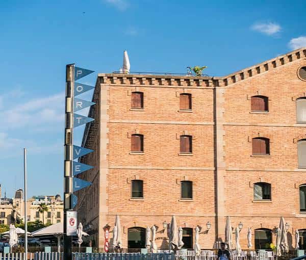 Fachada de edificio histórico en el Moll de la Barceloneta con terraza