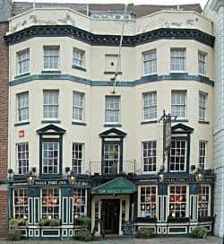 Fachada principal del The Sally Port Inn en Portsmouth, mostrando su arquitectura clásica con ventanas blancas y detalles en verde oscuro