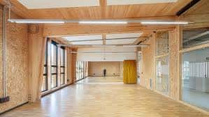 Interior espacioso del Ateneu con estructura de madera y grandes ventanales