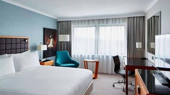 Habitación estándar del hotel con cama king-size, escritorio y decoración moderna