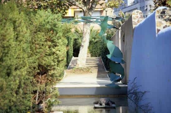 Escultura moderna junto a un estanque en los jardines