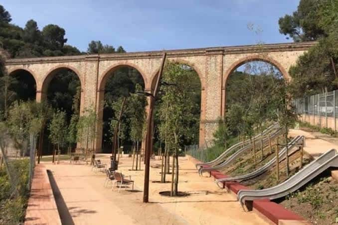 Vista del parque con el acueducto histórico al fondo y toboganes modernos