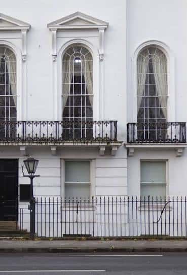 Detalle arquitectónico de ventanas arqueadas y balcones ornamentados del De Grey House
