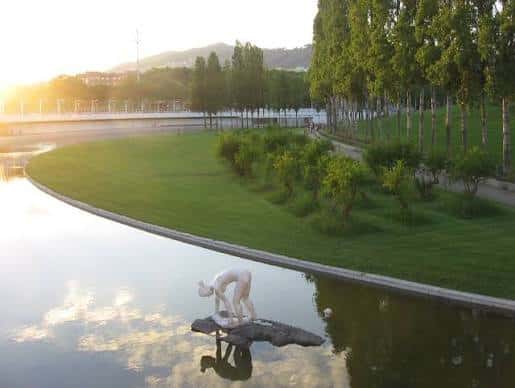 Escultura blanca junto al agua en el Parc de la Trinitat al atardecer
