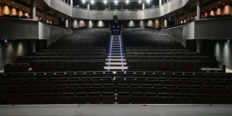 Vista general del auditorio del Teatro Goya desde el escenario, mostrando las gradas y el techo con iluminación