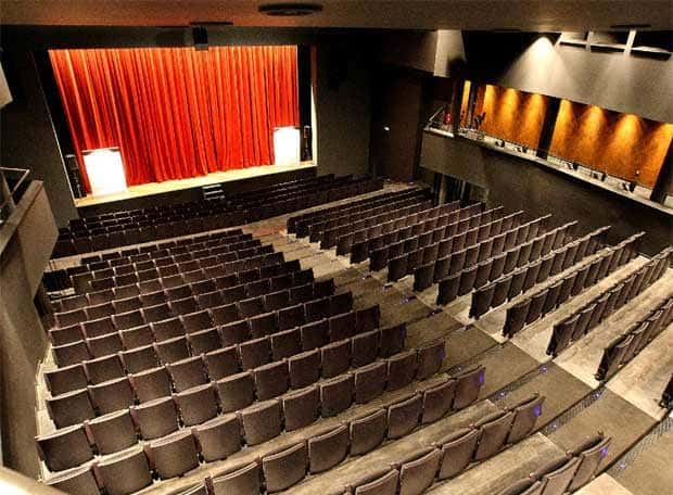 Ángulo elevado del auditorio del Teatro Goya, con cortinas rojas y butacas organizadas en filas