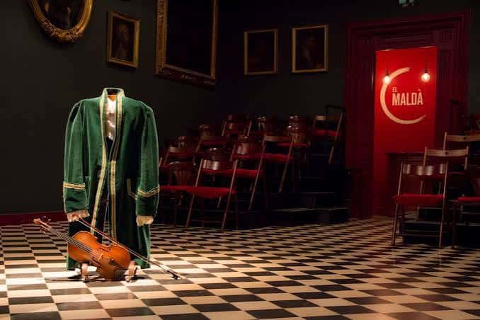 Escenario del teatro con traje histórico y violín en primer plano