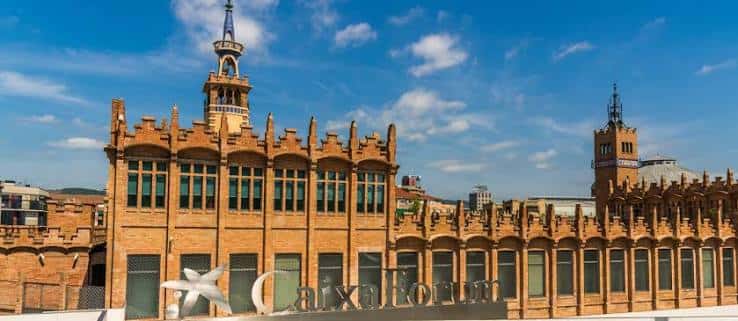 Fachada principal del CaixaForum Barcelona con el letrero del museo y el cielo azul de fondo