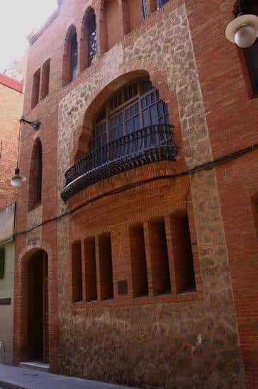 Fachada lateral del edificio con detalles de ladrillo y piedra