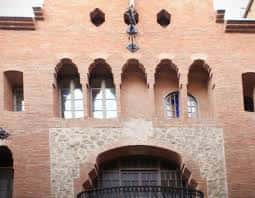 Detalle arquitectónico de la fachada principal con ventanas y balcón