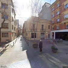 Plaza de Mañé i Flaquer en un día soleado, con edificios alrededor y una persona caminando